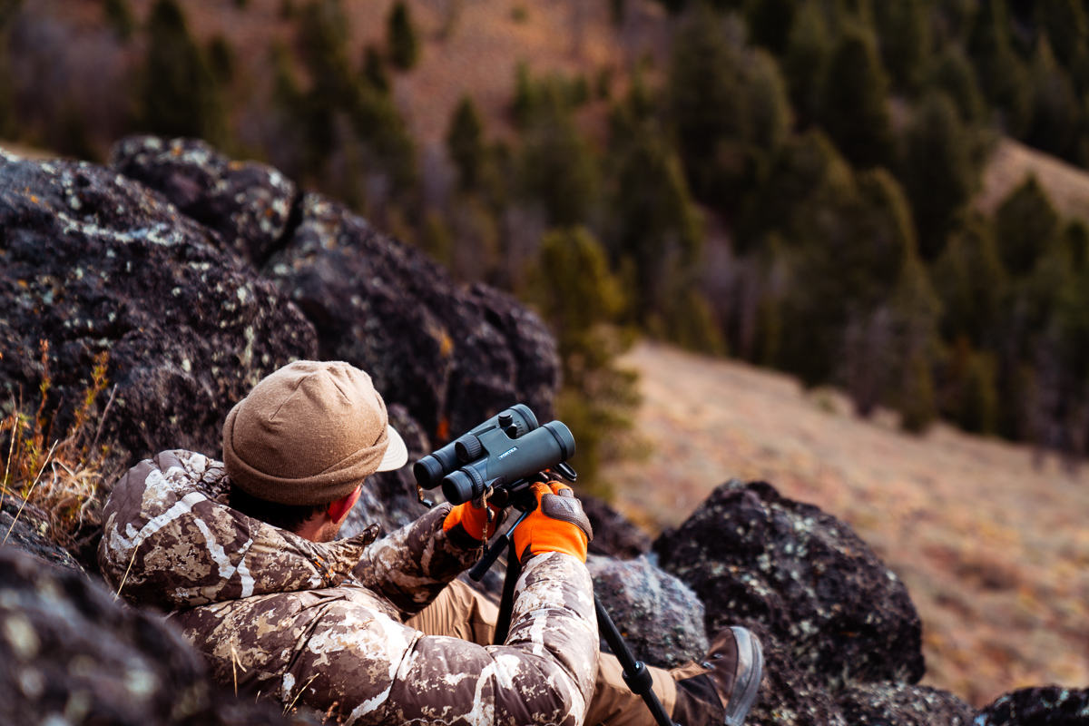 Hunter mounting binoculars on a tripod